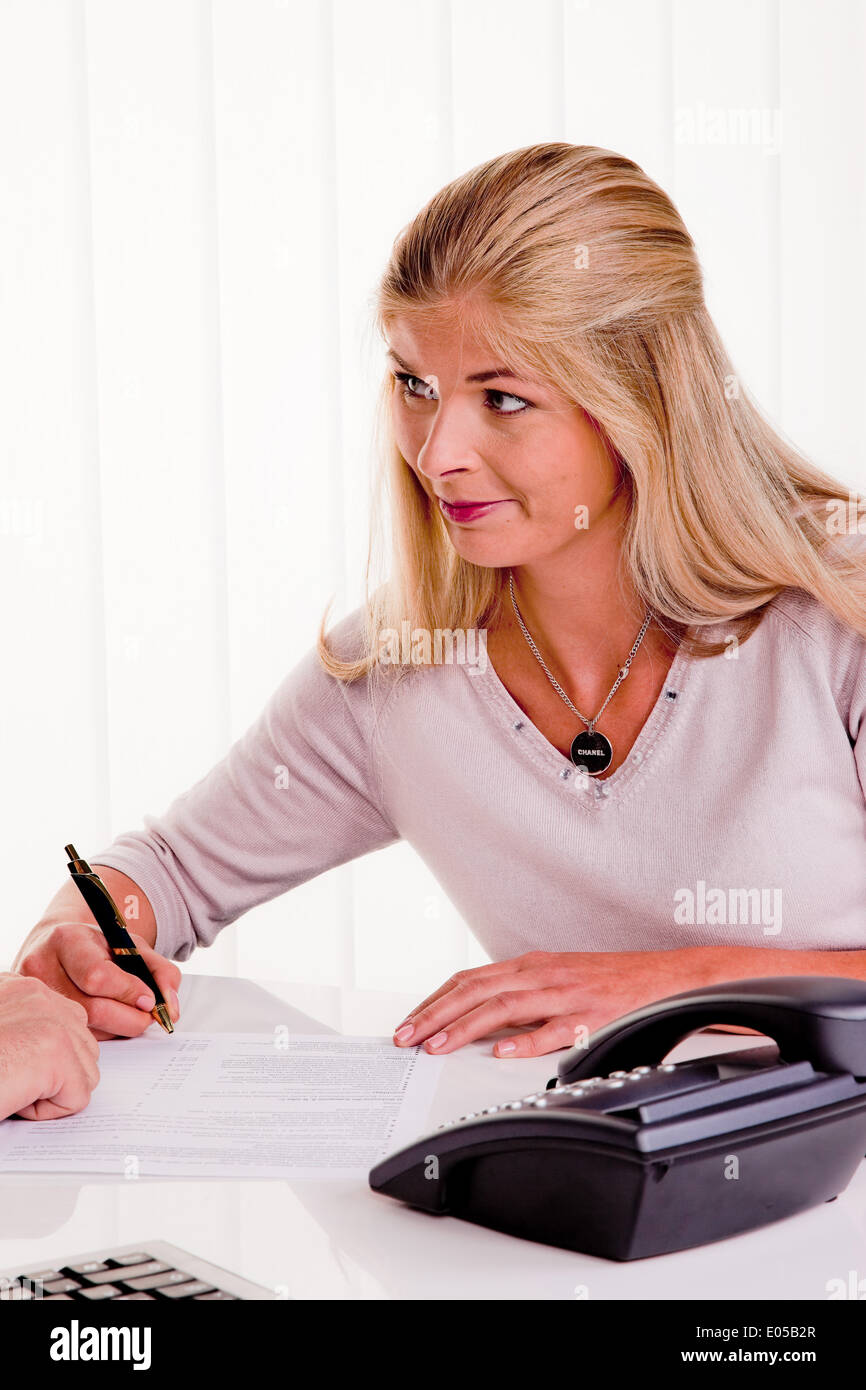Young woman signs a contract in an office, Junge Frau unterschreibt einen Vertrag in einem Buero Stock Photo