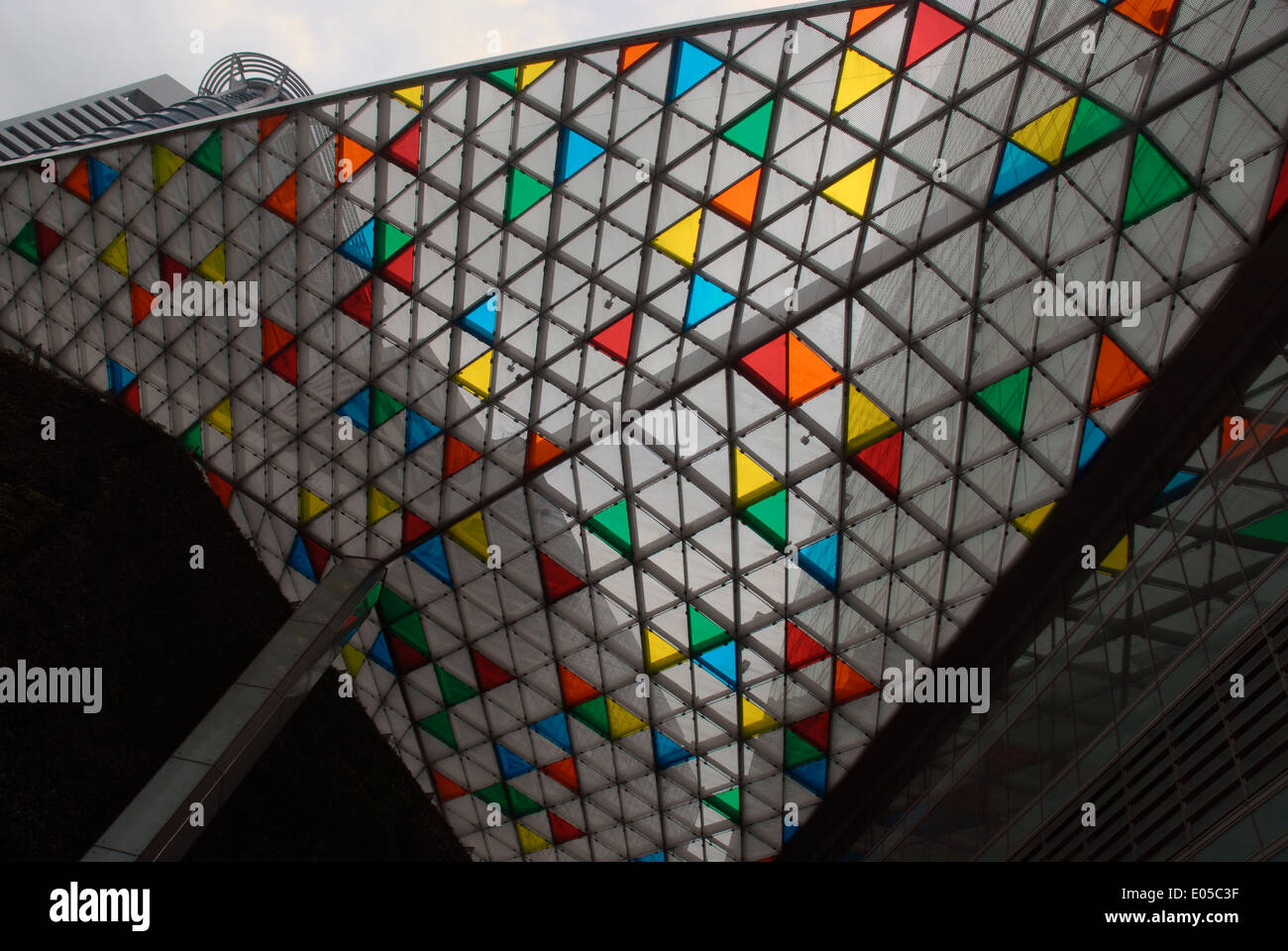 The brightly coloured glass roof tiles of a building in Singapore Stock