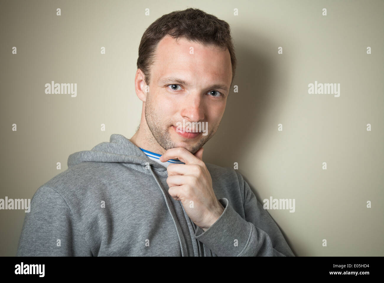 Young smart Caucasian man in gray sports jacket with hood Stock Photo
