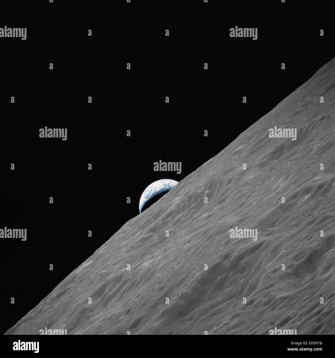 Cresent Earth rises above lunar horizon Stock Photo