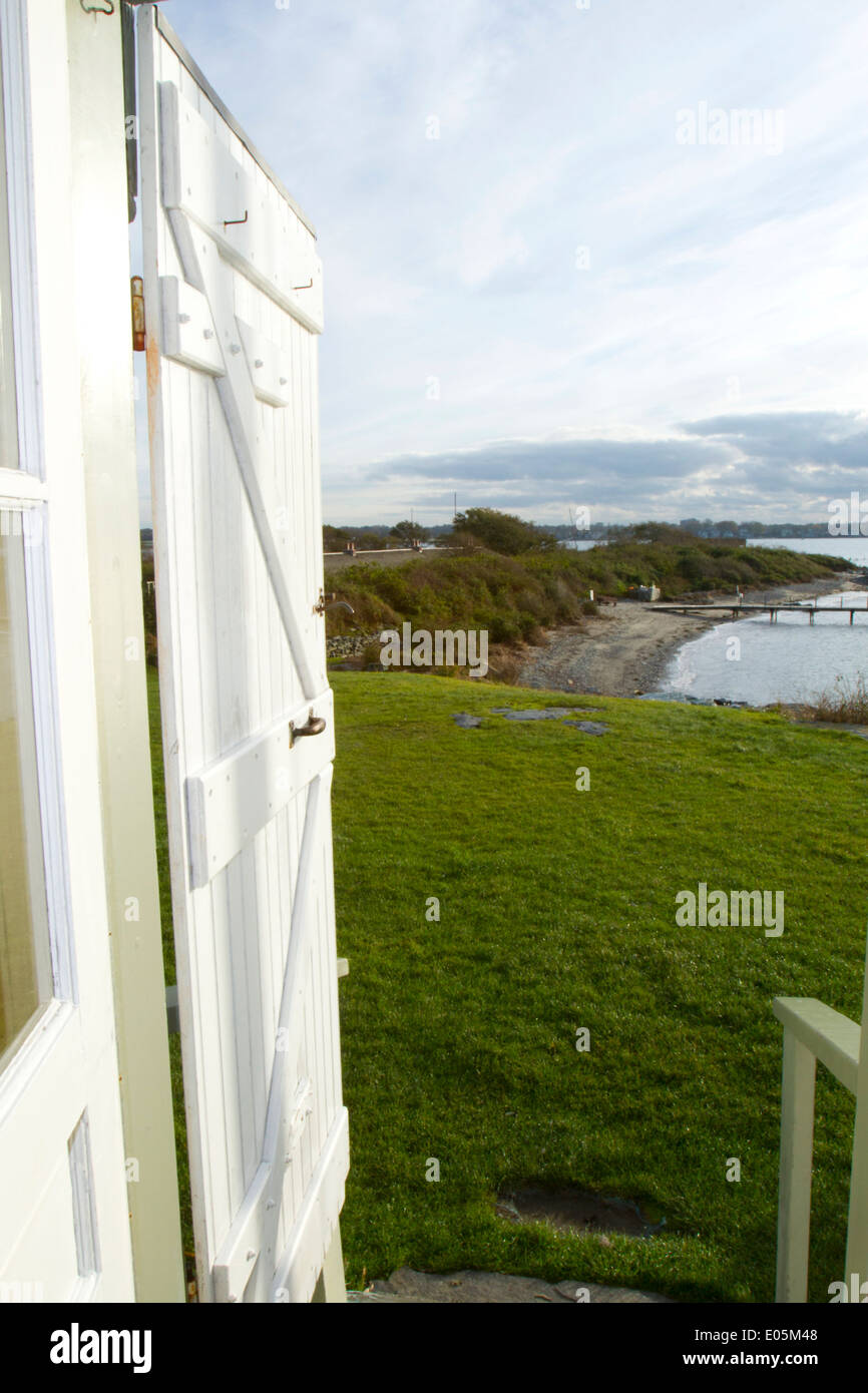 Open wooden door showing coastline representing the concept of living at the shore Stock Photo