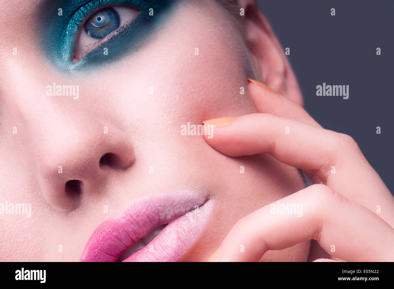 Beauty macro close up of a Caucasian young woman's face with blue eye shadow and pink ombre lips Stock Photo