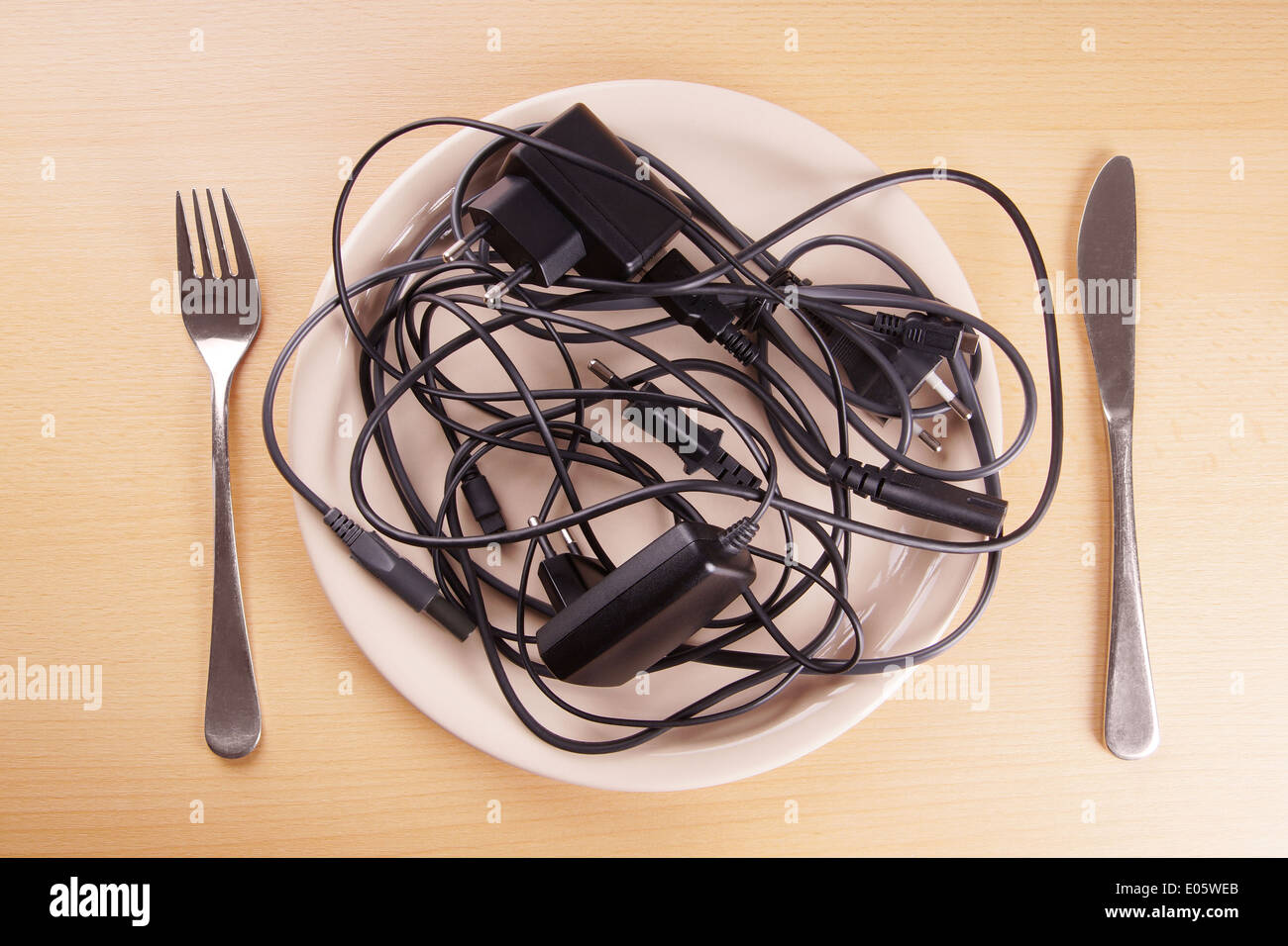 cable tangle on a plate symbolising the German term Kabelsalat (cable salad) also known as spaghetti syndrome Stock Photo