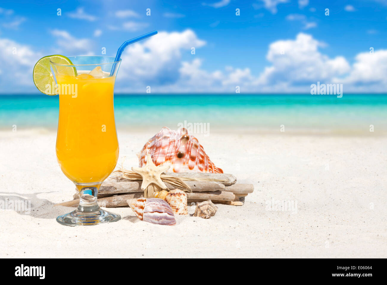 Fruit Cocktail with Orange and Drinking Straw on the Beach with some ...