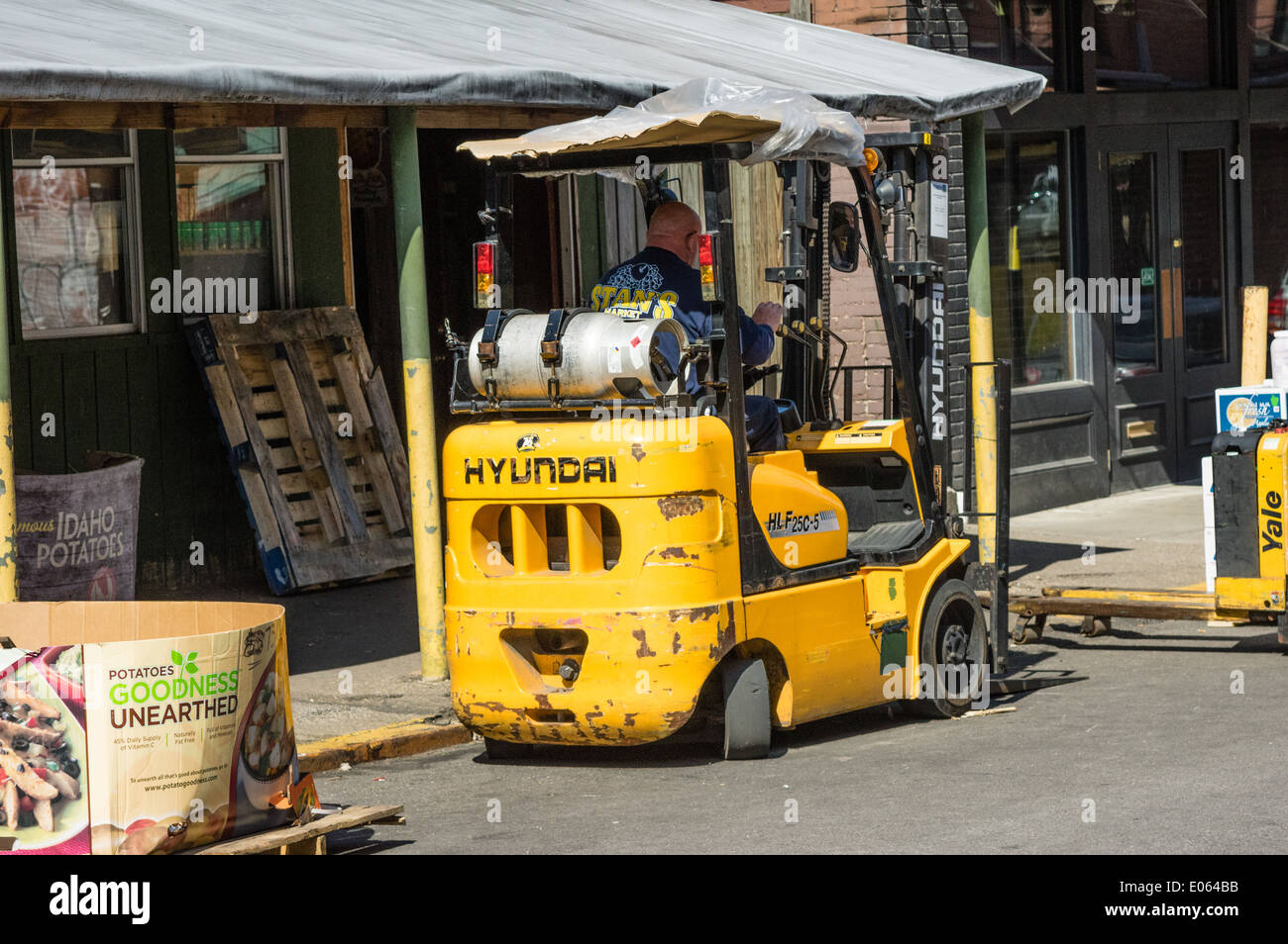 Worker operating a forklift in the street. Strip District, Pittsburgh
