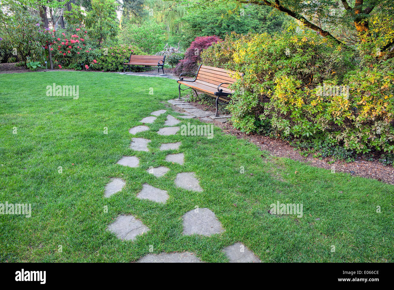 Natural Stone Steps on Green Grass Lawn to Park Bench Stock Photo