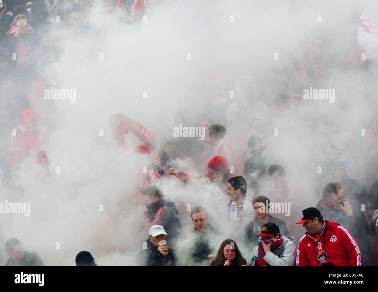 Toronto, Canada. 3rd May, 2014. Fans of Toronto FC surrounded by smoke cheer for their team during the 2014 Major League Soccer (MLS) match between Toronto FC and New England Revolution in Toronto, Canada, May 3, 2014. Toronto FC lost 1-2. Credit:  Zou Zheng/Xinhua/Alamy Live News Stock Photo