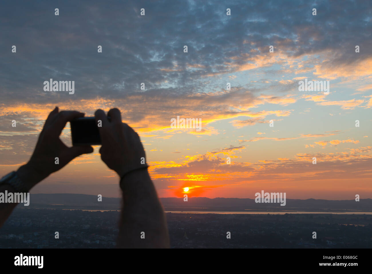 Tourist photographing Ayarwaddy River and sky at sunset, Mandalay, Myanmar Stock Photo