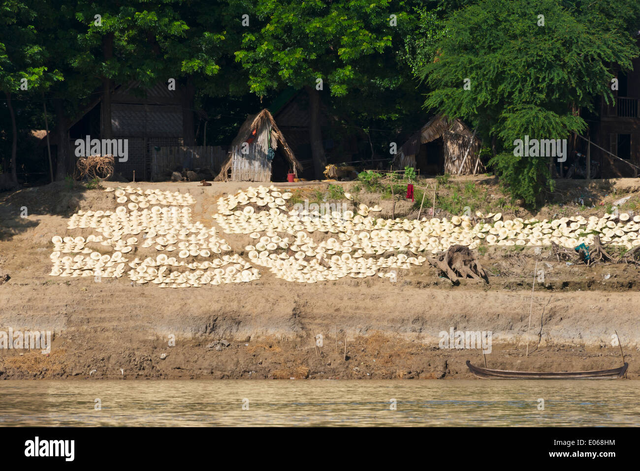 Drying handmade straw hats on the river bank of the Ayarwaddy River, Myanmar Stock Photo