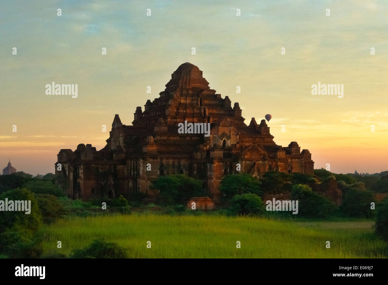 Tourist hot air balloon with ancient temple and pagoda in the jungle at sunrise, Bagan, Myanmar Stock Photo