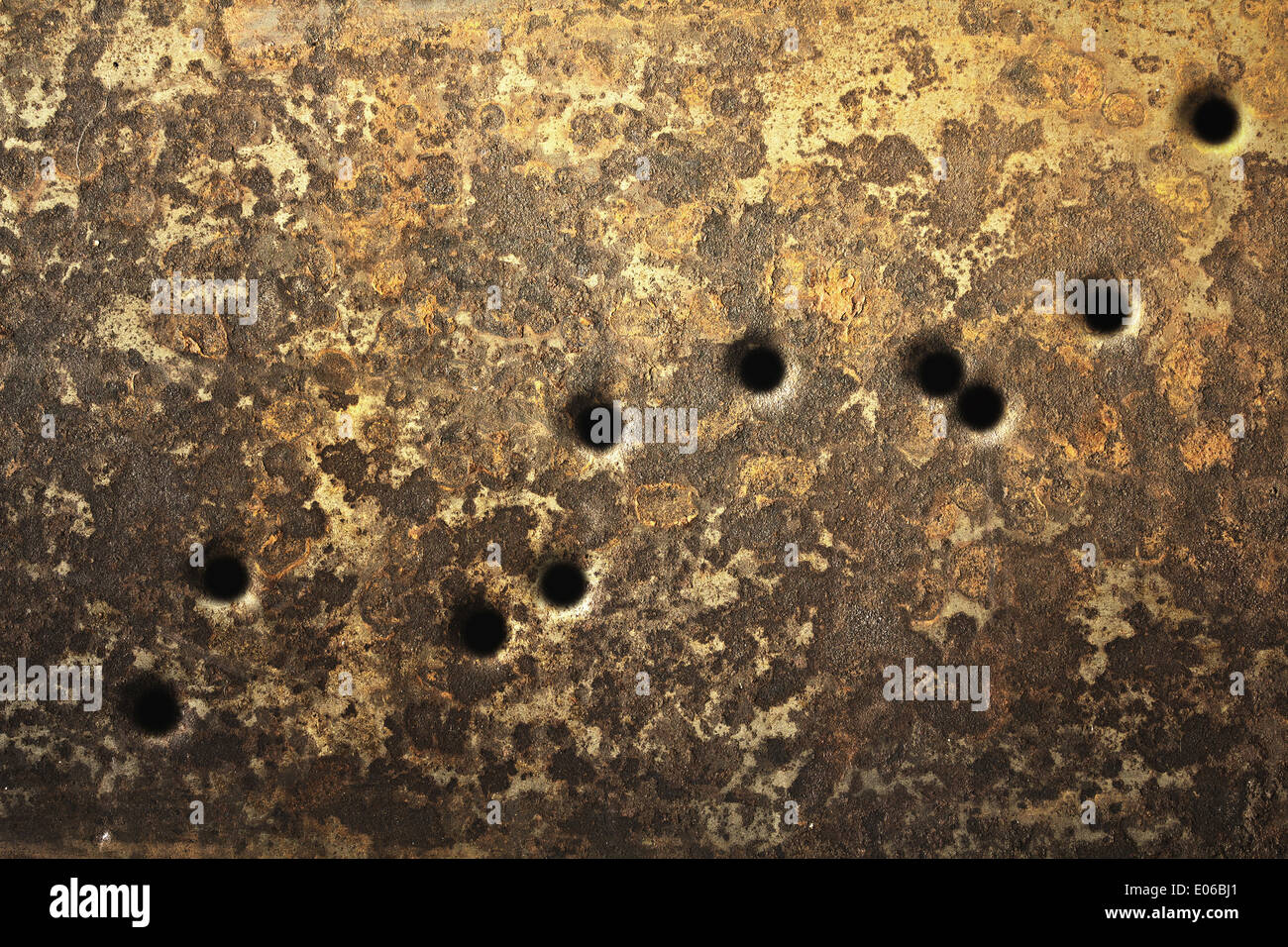 Rusty metallic surfaces perforated with bullet holes. Stock Photo