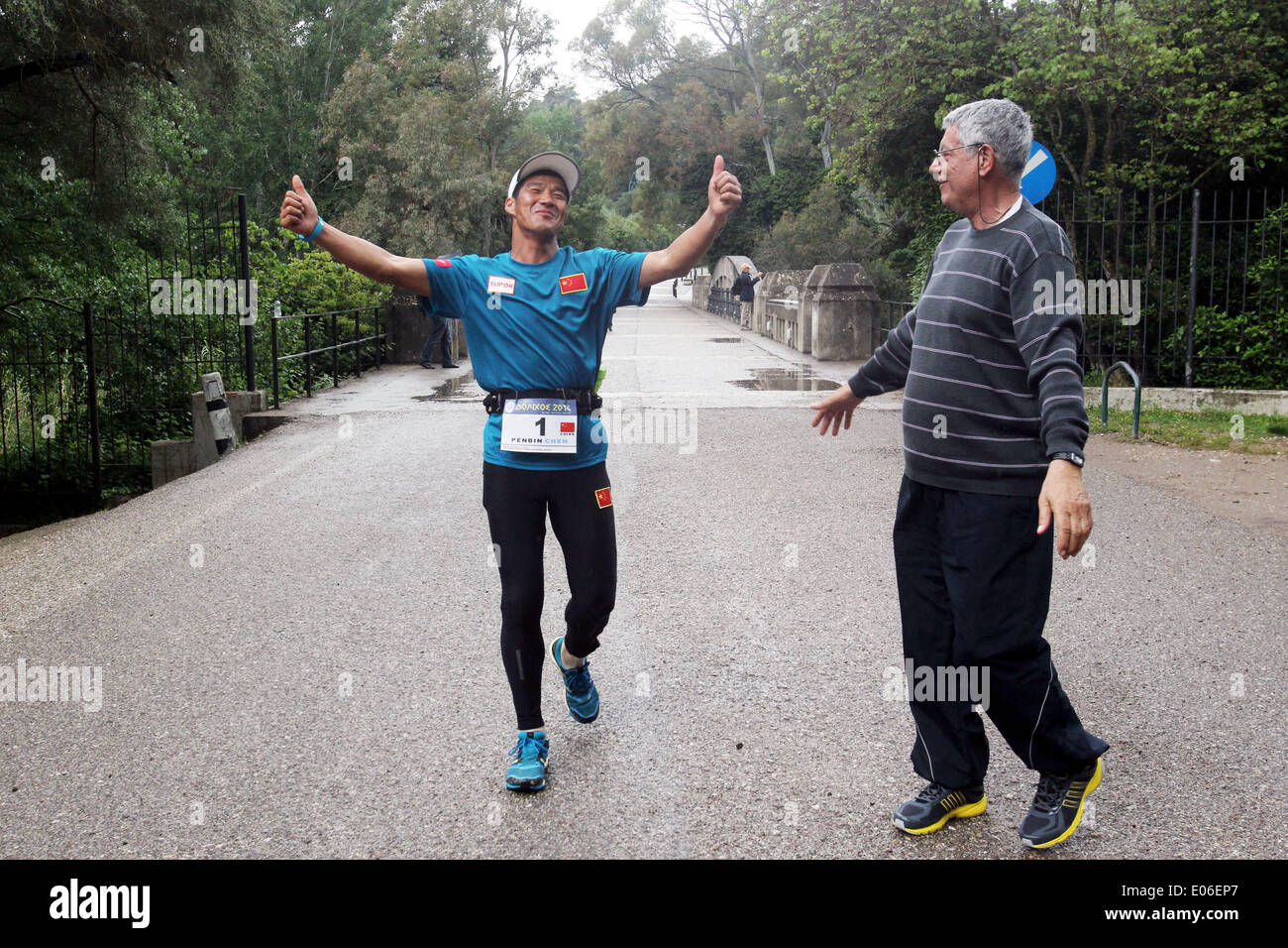 Athens, Greece. 4th May, 2014. Chinese runner Chen Penbin (L) who finished 3rd reaches the finish line during the 3rd Dolichos Ultra Marathon in front of the archaeological site of Olympia, Greece, on May 4, 2014. A total of 26 athletes started on Friday running nonstop a 255 kilometers race from Delphi in mainland Greece to the birthplace of the Olympic Games. © Marios Lolos/Xinhua/Alamy Live News Stock Photo