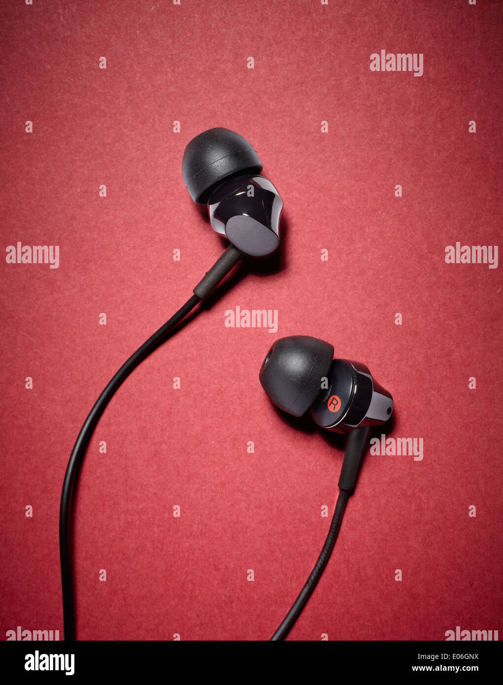 inner ear headphones against a red background Stock Photo