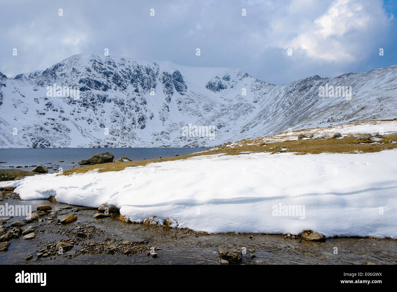 Red Tarn and snow on Helvellyn mountain with Swirral Edge in mountains of Lake District National Park, Cumbria, England, UK, Britain Stock Photo