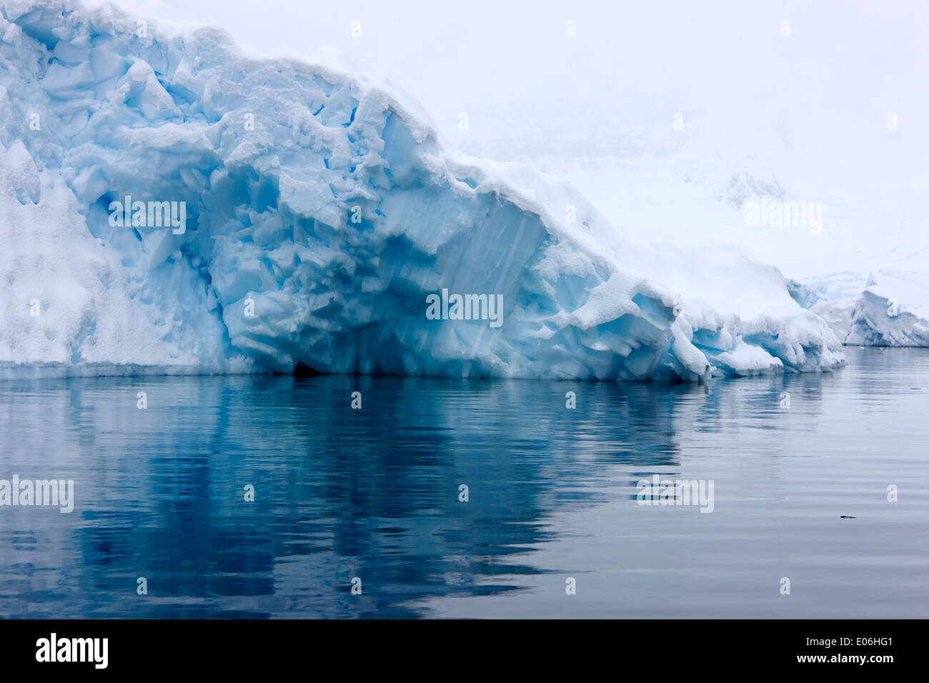 snow covered blue ice shelf falling into the sea at Fournier Bay
