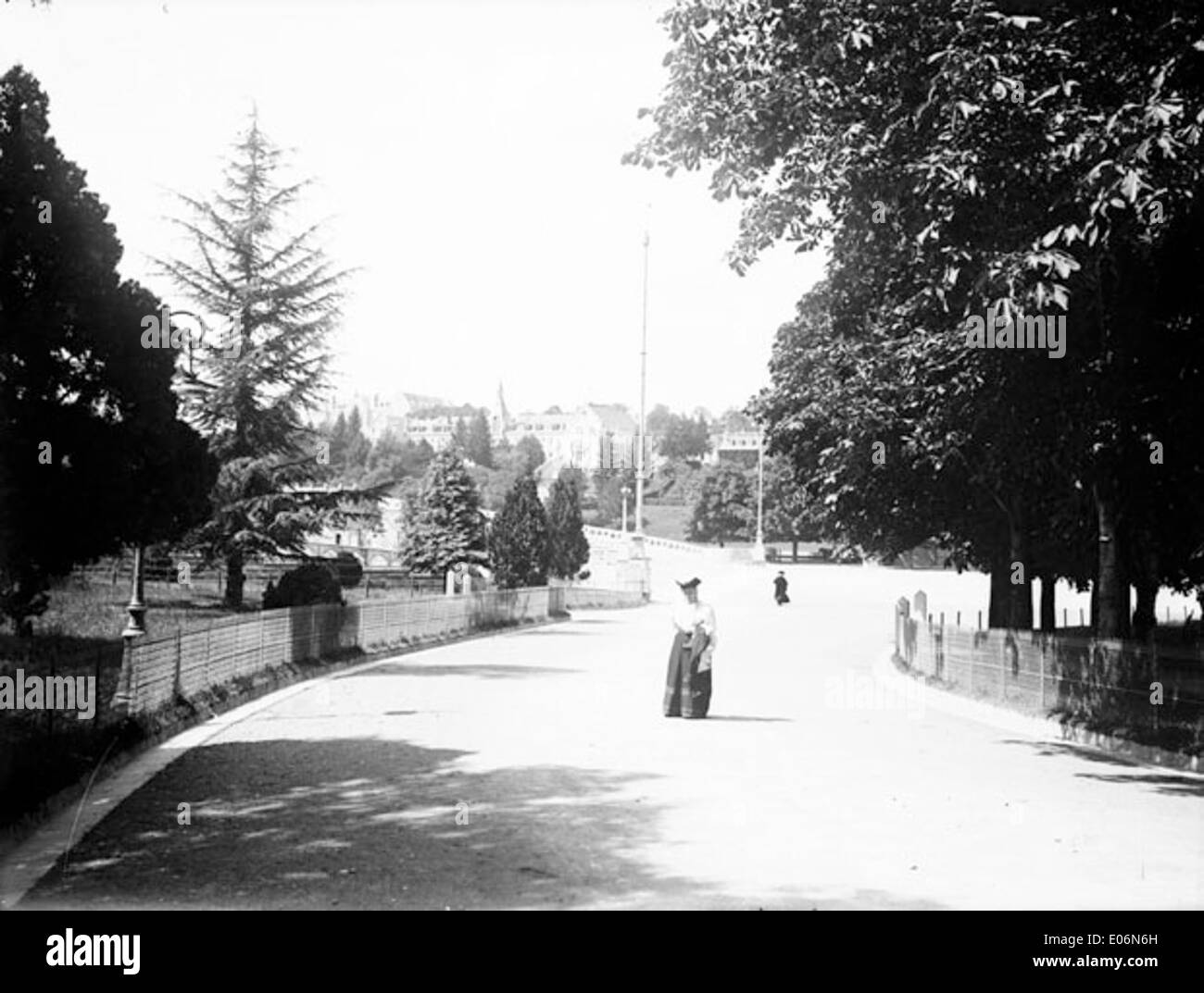 A photograph taken on July 13, 1906, of the Allée de la Grotte in Lourdes, a path leading to the famous grotto where the Virgin Mary is believed to have appeared. The photo captures the serene atmosphere and pilgrimage route. Stock Photo