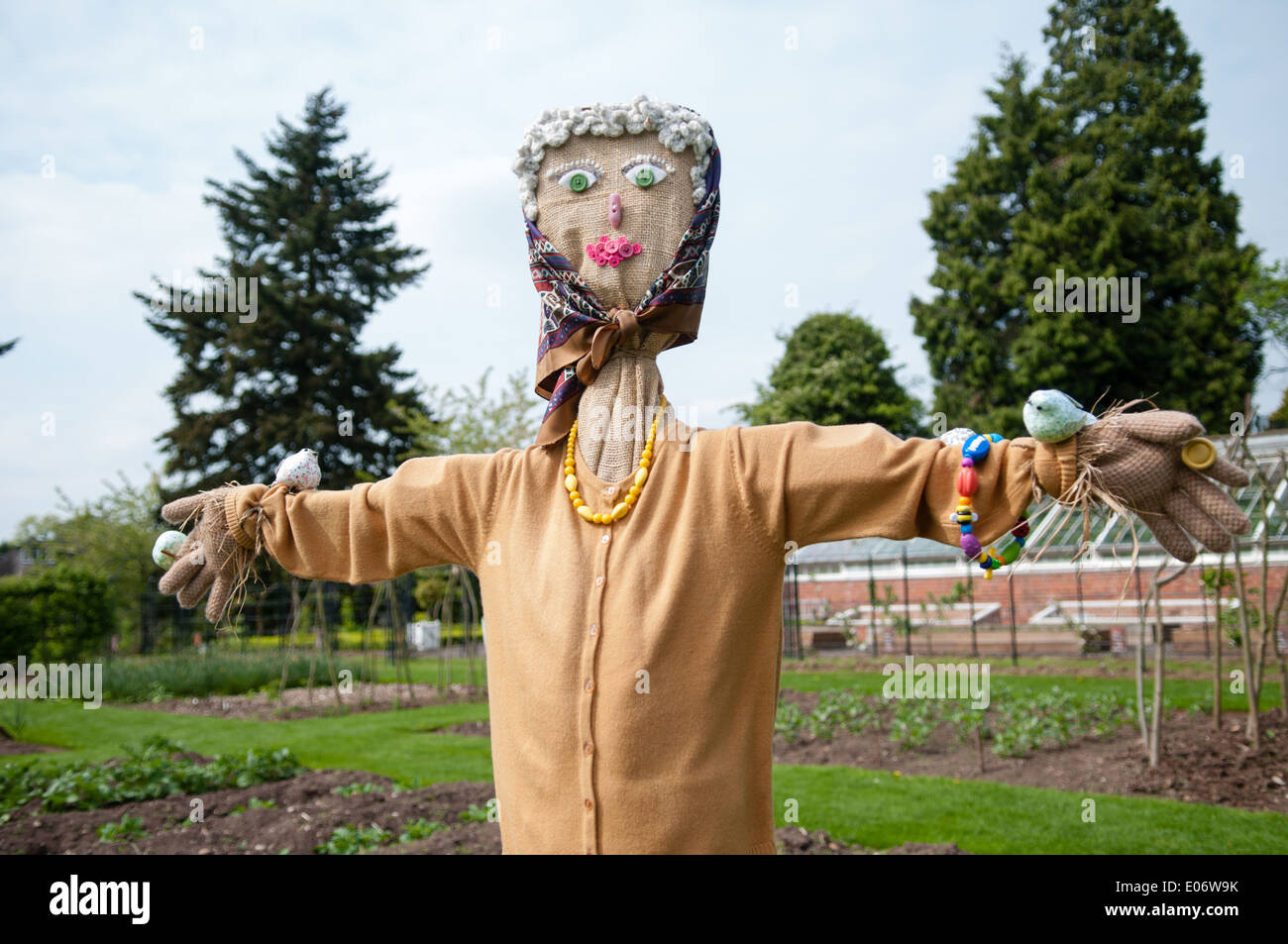 Cute old lady scarecrow wearing pearls, a head scarf and cardigan in the walled garden at National Trust house Wightwick Manor Stock Photo