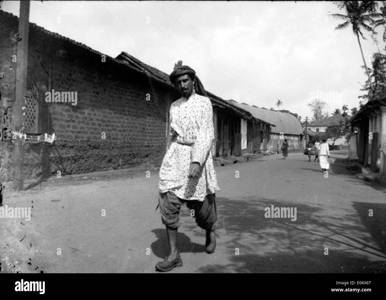 A man dressed in traditional attire with a turban, walking in the ...