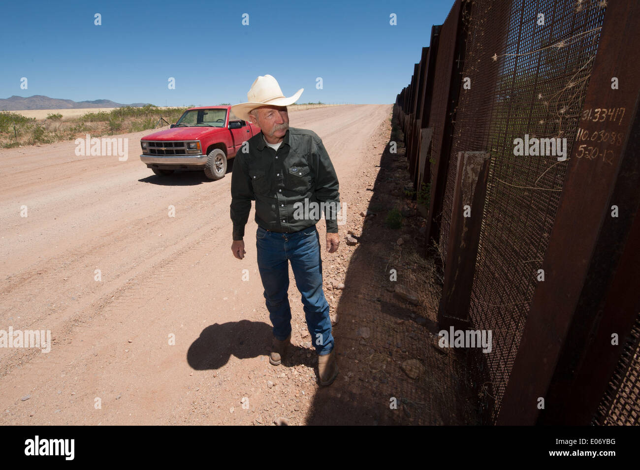 Naco, Arizona, USA. 28th Apr, 2014. Arizona cattle rancher JOHN LADD's ranch near Naco, Ariz., abuts the border fence separating the U.S. and Mexico. Over the years he's had problems caused by both smugglers and U.S. Border Patrol agents including damage to his property, livestock and grass. Ladd looks at a section of border fence repaired in 2012 after smugglers cut a hole in it and drove trucks through his property. © Will Seberger/ZUMAPRESS.com/Alamy Live News Stock Photo