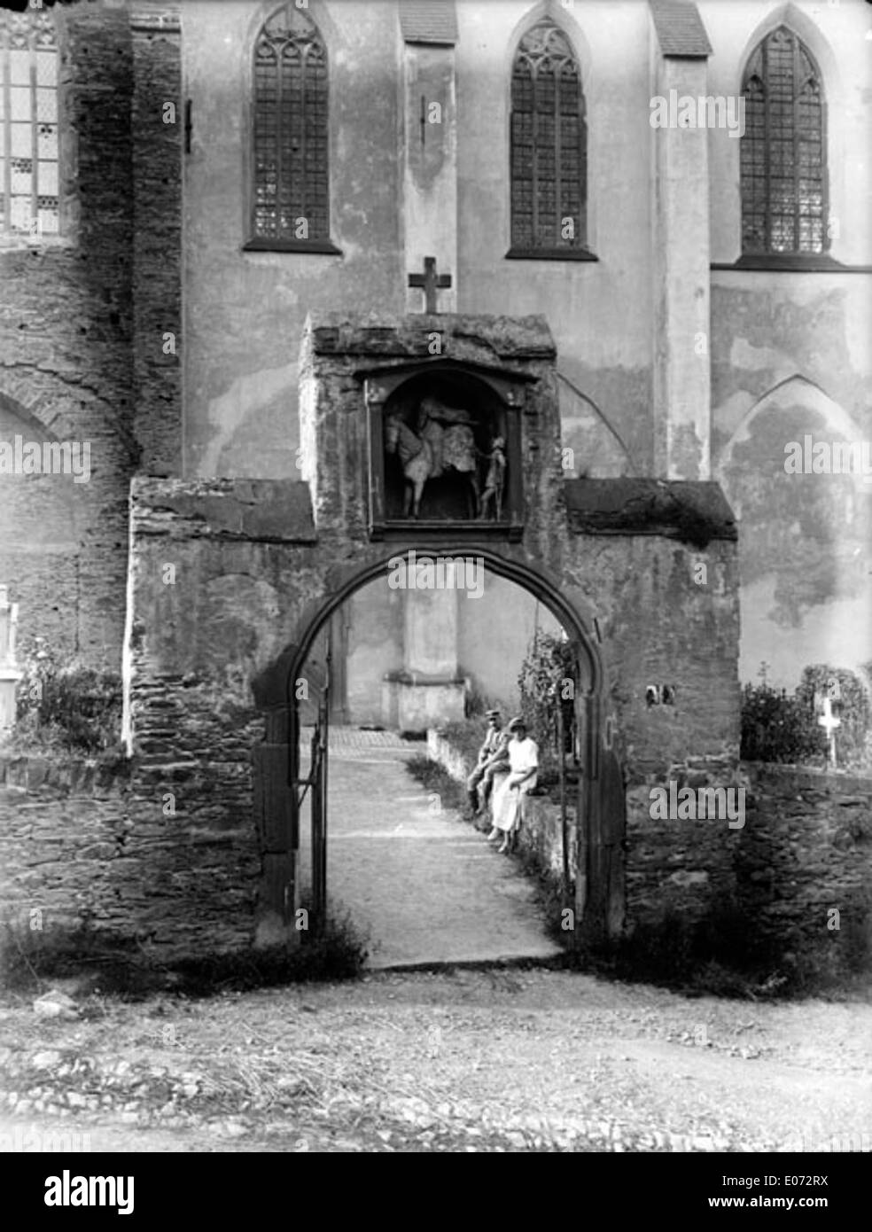 This artwork illustrates the entrance gate of a cemetery and its associated church in Germany. The historical piece offers insight into European burial sites and architectural designs from a bygone era. Stock Photo