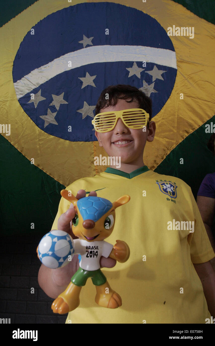 Rio De Janeiro, Brazil. 4th May, 2014. A boy shows a figure of official mascot Fuleco in the Santa Clara alley in the city of Niteroi in the state of Rio de Janeiro, Brazil, on May 4, 2014. The residents start to decorate the street on Sunday for the next FIFA World Cup. © Alessandro Costa/Agencia Estado/Xinhua/Alamy Live News Stock Photo