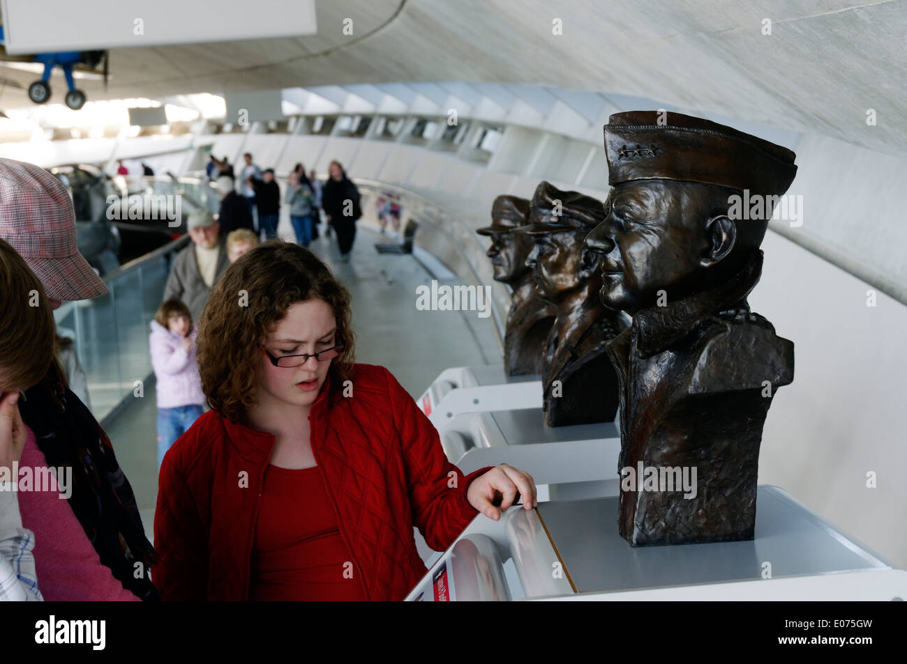 A young woman looking at the bust of James Doolittle, head of the US eight Air Force during WW2, at Duxford Air Museum Stock Photo