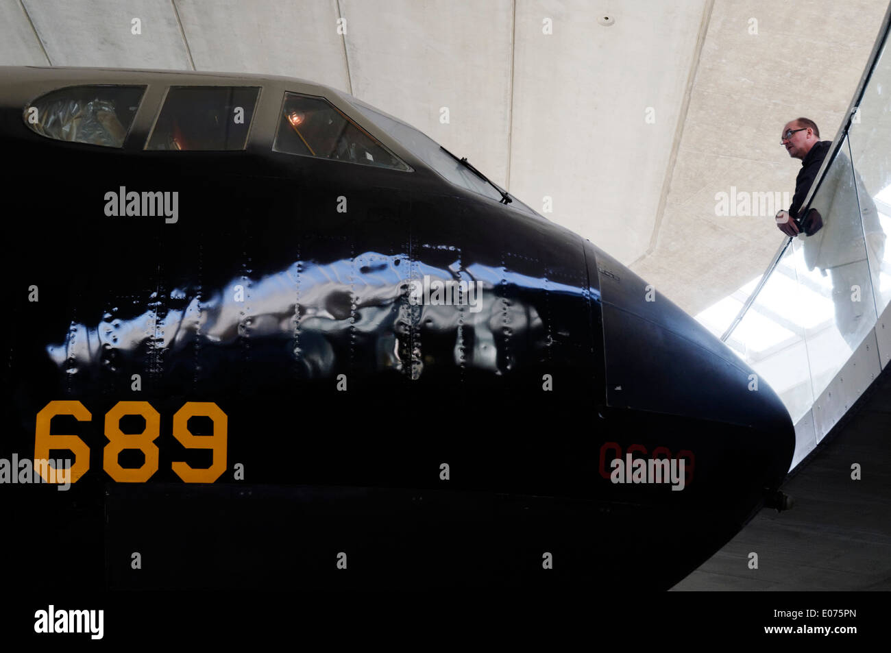 A man looking at the huge Boeing B-52 Stratofortress on exhibit at Duxford Air Museum Stock Photo