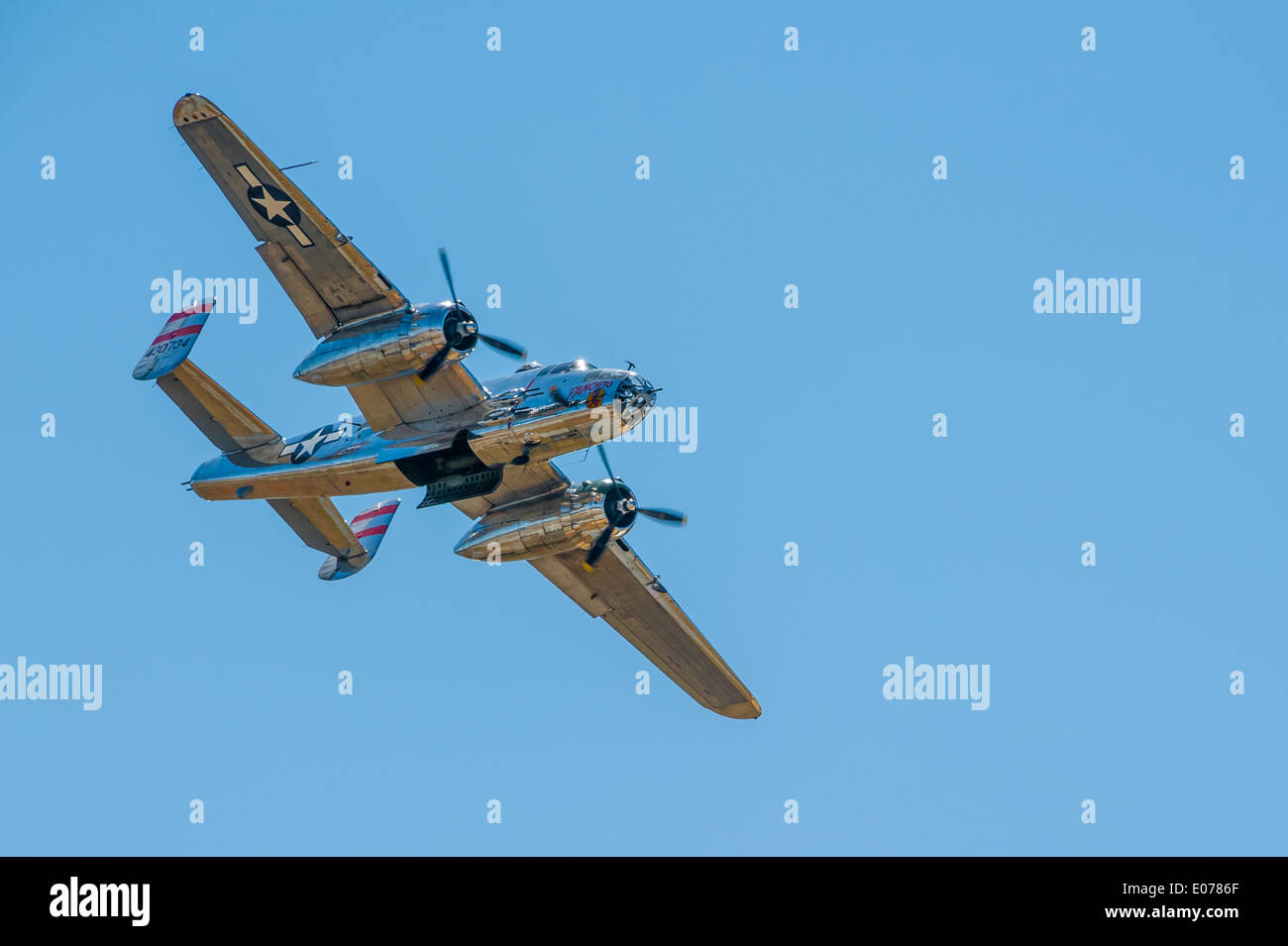 Chrome bodied, World War II era, Mitchell B-25 bomber against a clear, blue sky over Columbus, Georgia, USA. Stock Photo