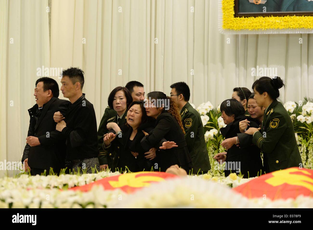 Shanghai, China. 5th May, 2014. Relatives wail as they mourn for Qian Lingyun and Liu Jie, two young Chinese firefighters who fell to their death during a blaze in a highrise building, at a memorial meeting in Shanghai, east China, May 5, 2014. Qian Lingyun and Liu Jie, who were born in 1991 and 1994 respectively, died on May 3 while responding to the fire in an apartment on the 13th floor of the building where a sudden blast occurred and the force blew them through an open window. © Lai Xinlin/Xinhua/Alamy Live News Stock Photo