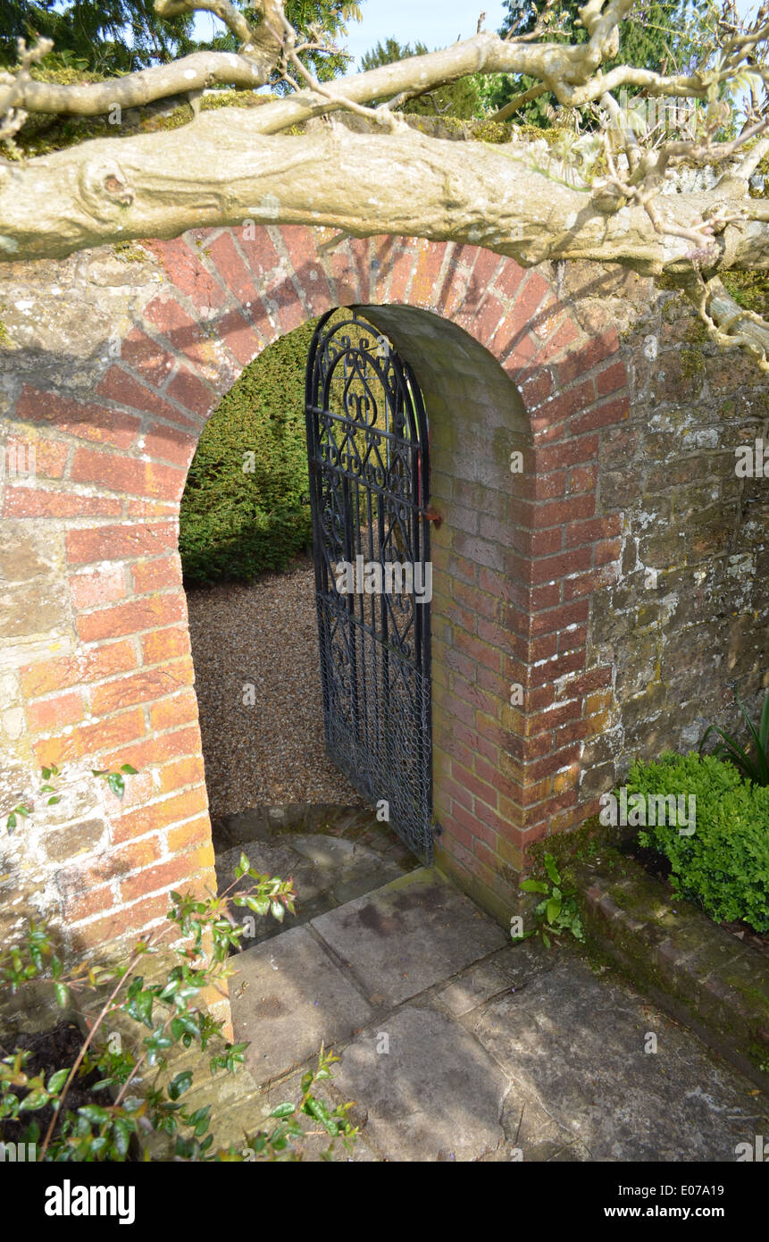 Arched brick doorway with iron gate in a formal English 