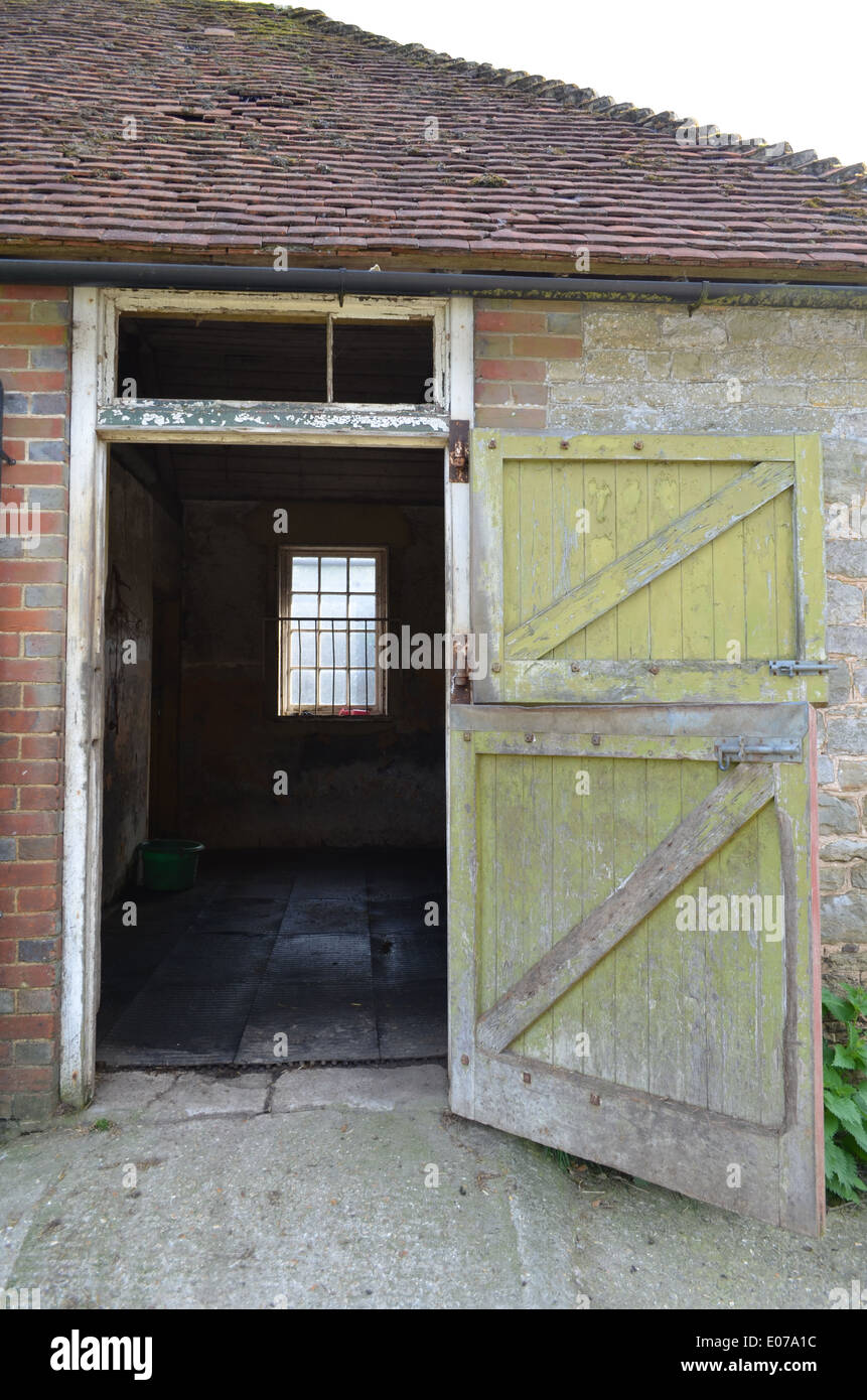 open-wooden-stable-door-attached-to-a-brick-and-tiled-building-in-E07A1C.jpg