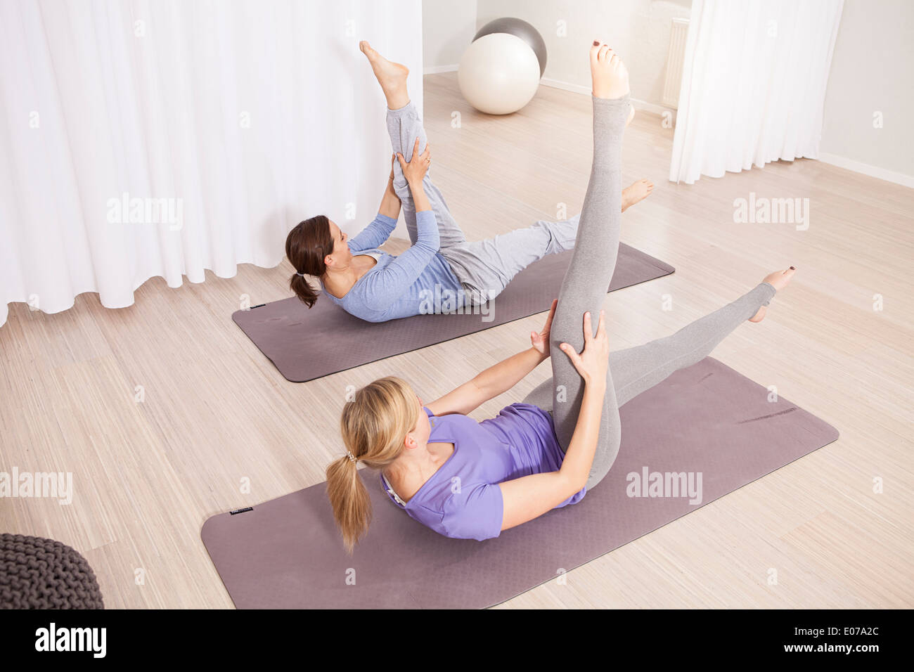 Two women doing Pilates exercise, feet up Stock Photo