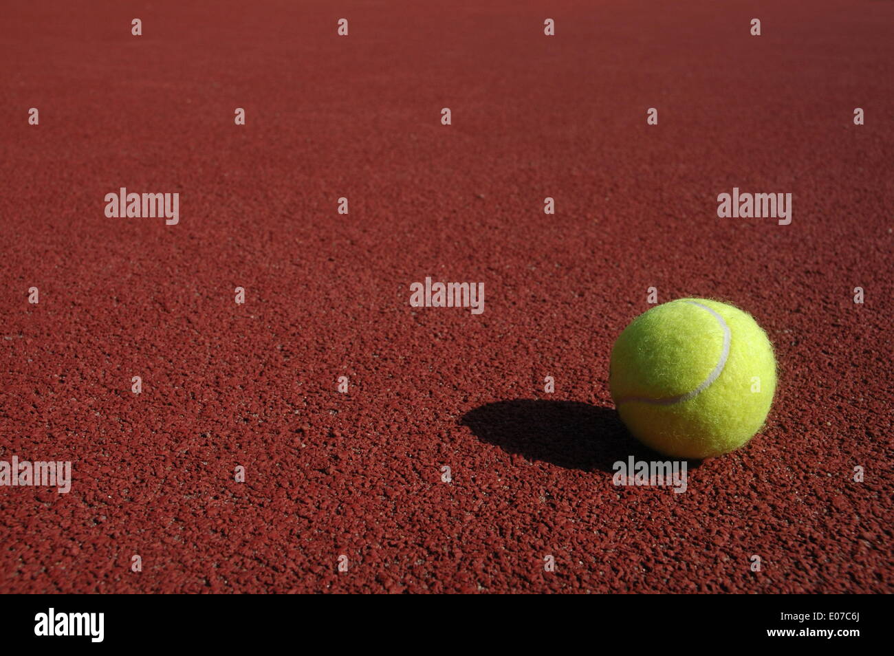 Illustration - A tennis ball sits on the red court in Germany, 17 September 2009. Fotoarchiv für ZeitgeschichteS. Steinach - NO WIRE SERVICE Stock Photo