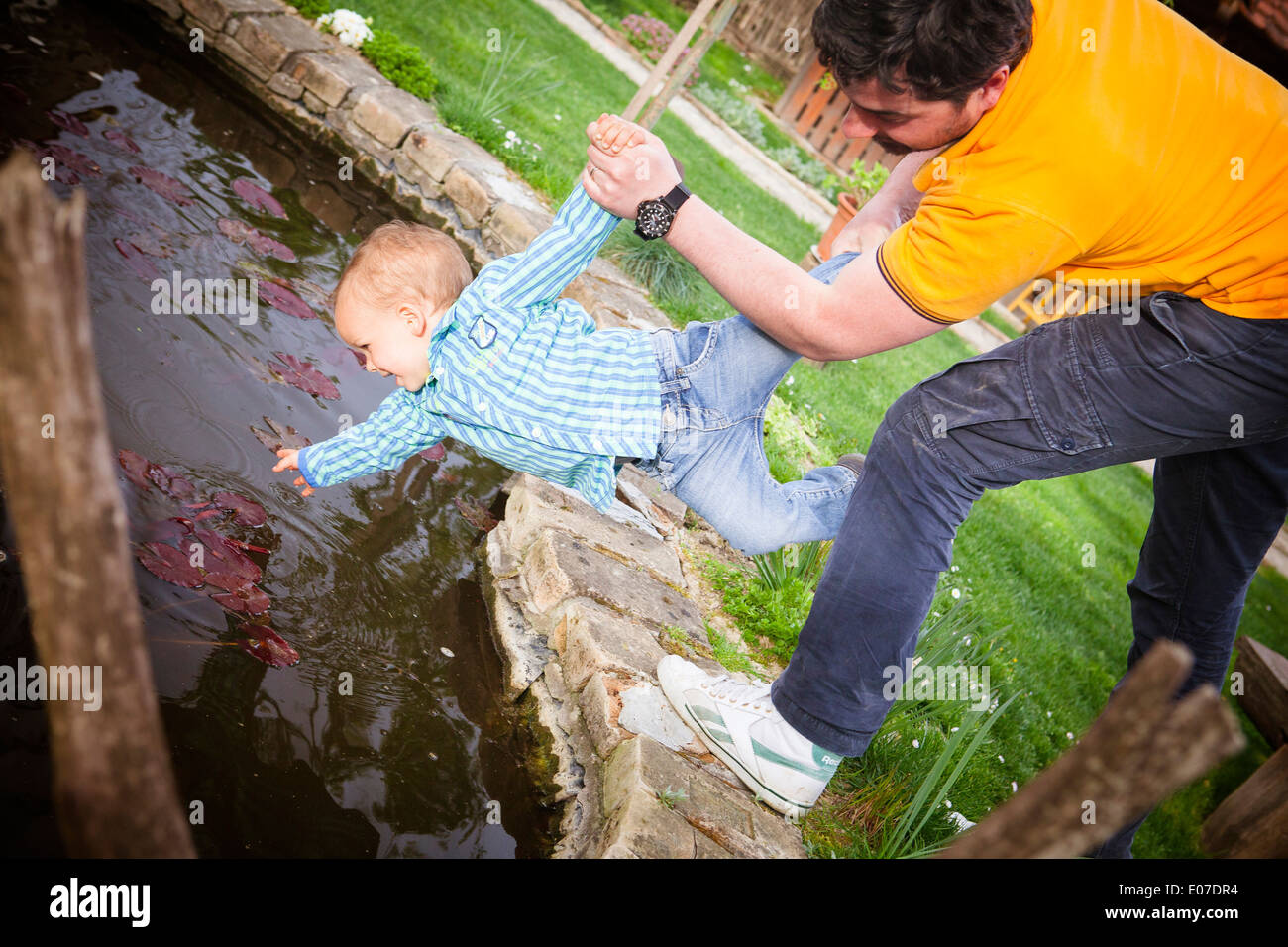 Father and son fooling around on the waterfront, Austria Stock Photo