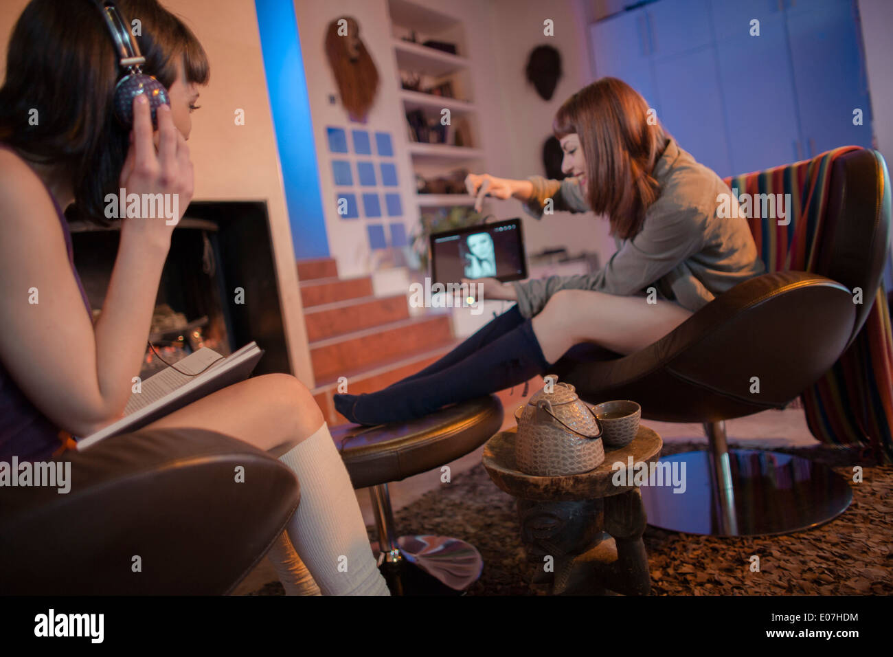 Two young women relaxing at home looking at digital tablet Stock Photo