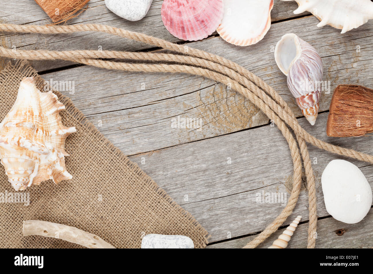 Sea travel frame decor with seashells and rope over wooden background Stock Photo