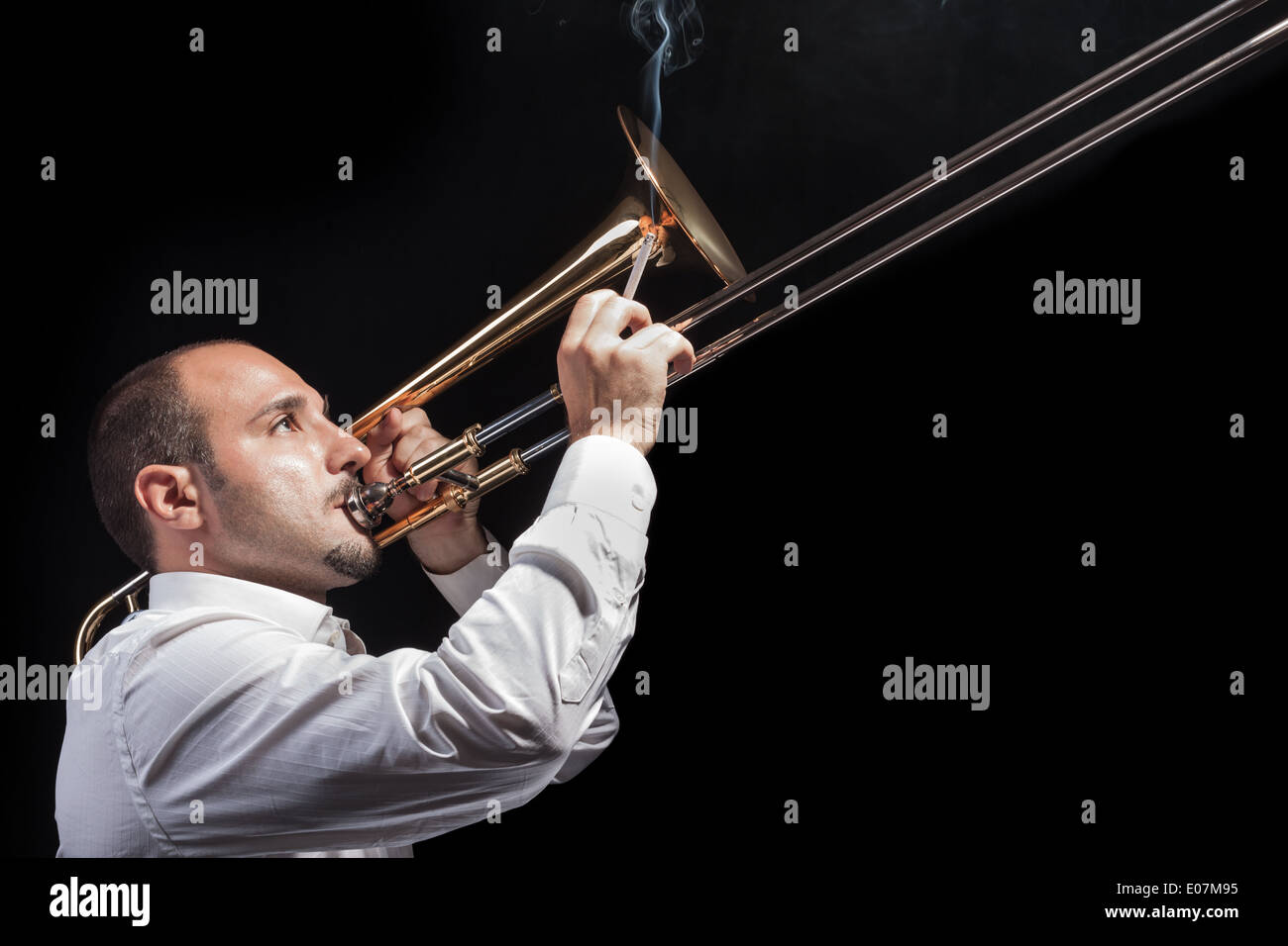 a young jazzer with a trombone over black background Stock Photo Alamy