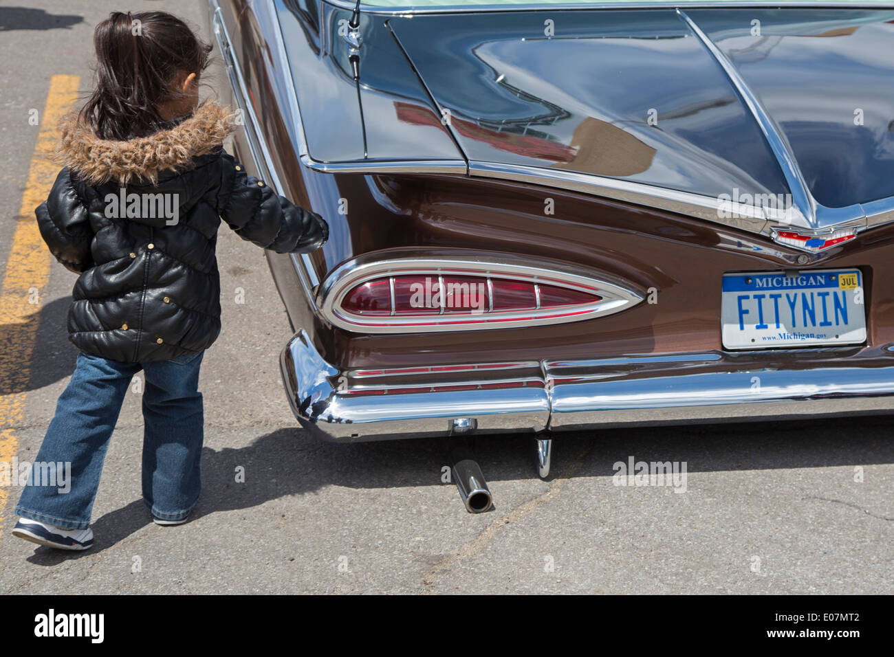 Detroit, Michigan - A young girl checks out a 1959 Chevrolet lowrider at the Blessing of the Lowriders. Stock Photo