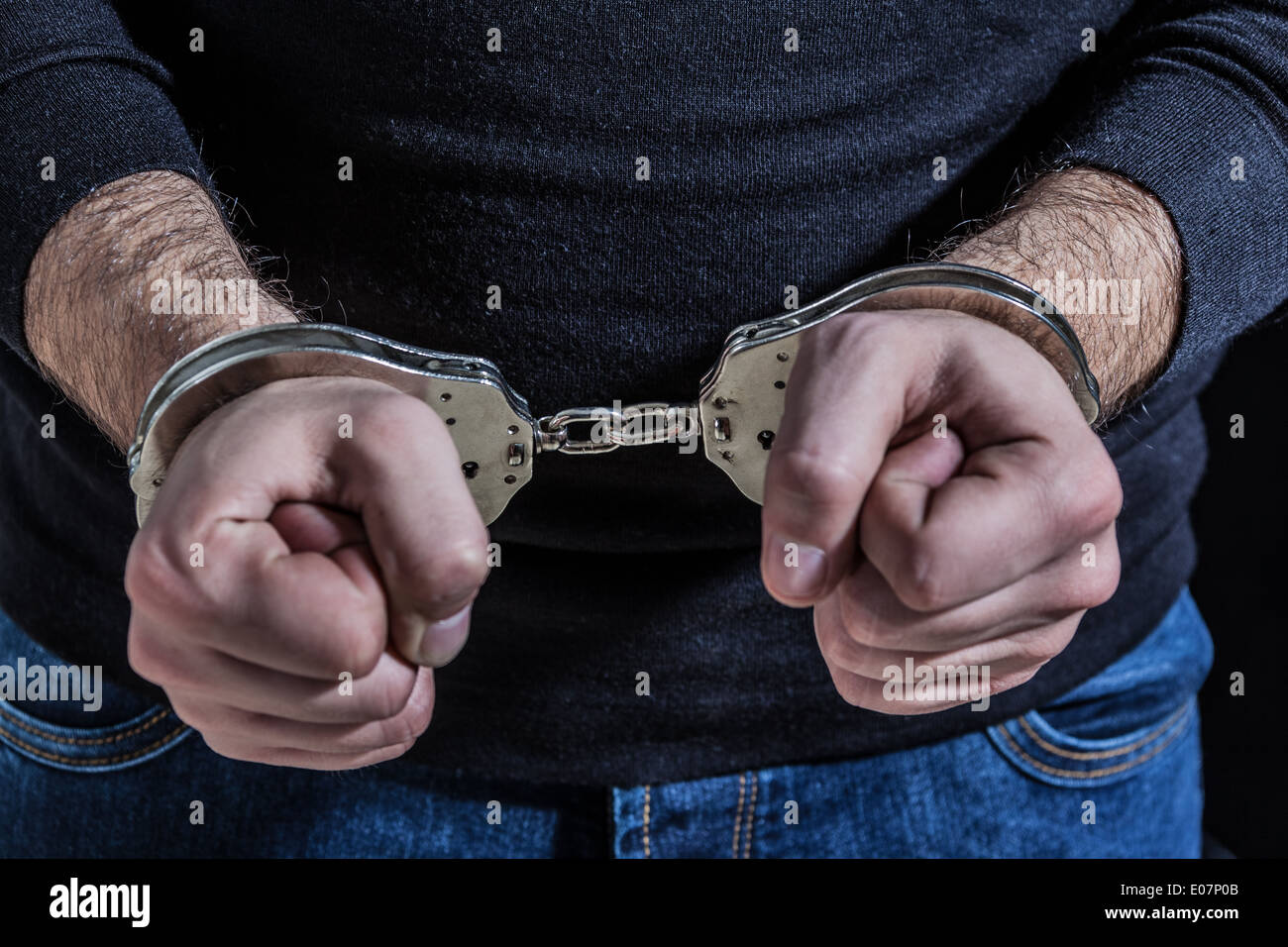 a thief arrested with handcuffs and wearing a black shirt Stock Photo
