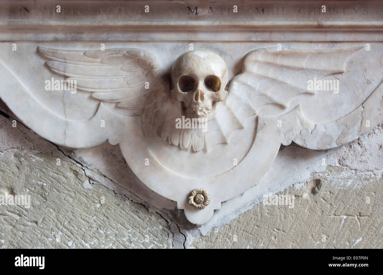Skull with angel wings marble carving carved on base of memorial on wall in church Funerary monument Gresford North Wales UK Stock Photo