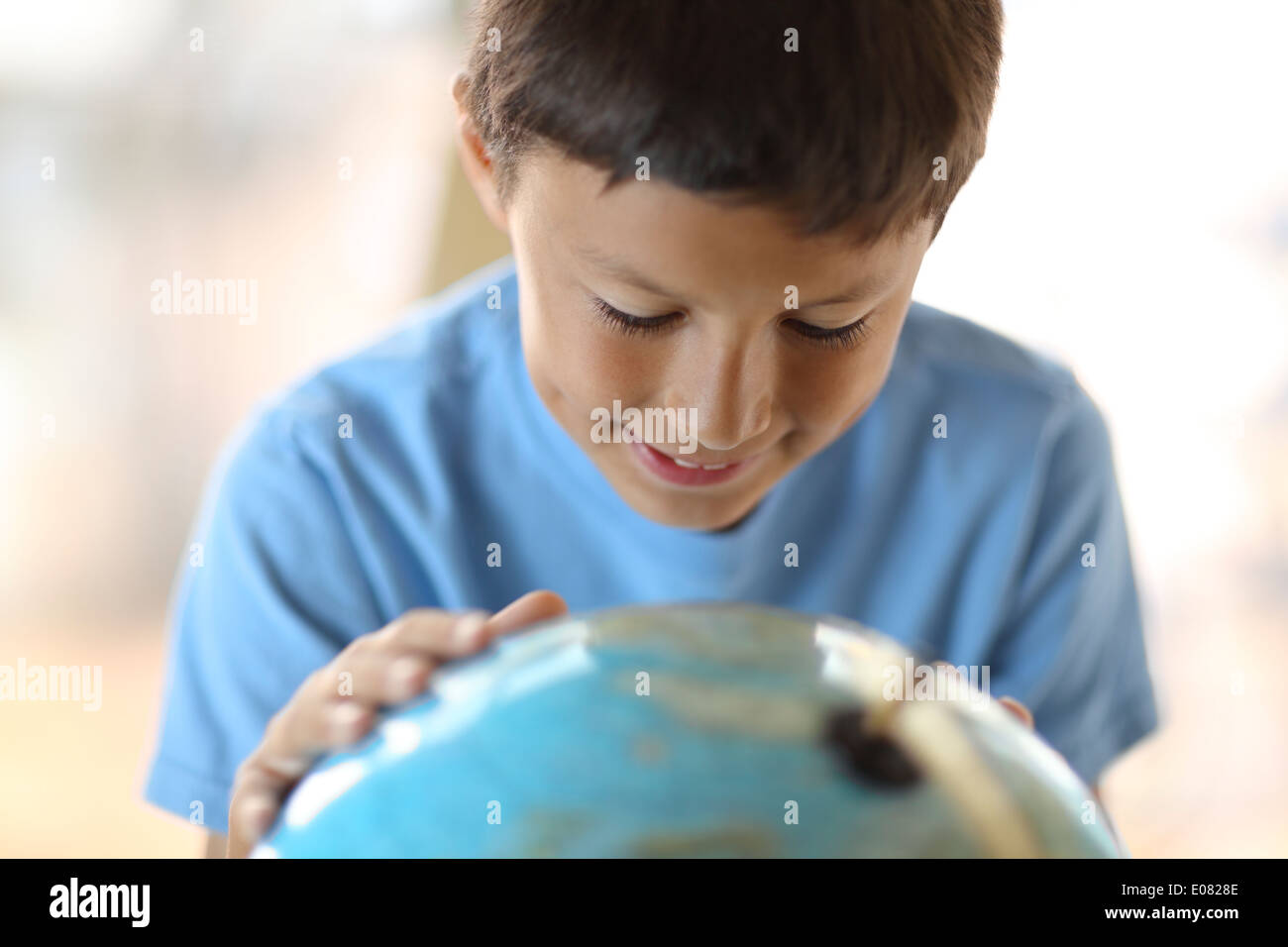 Y0oung boy dreams of traveling as he looks at a globe Stock Photo