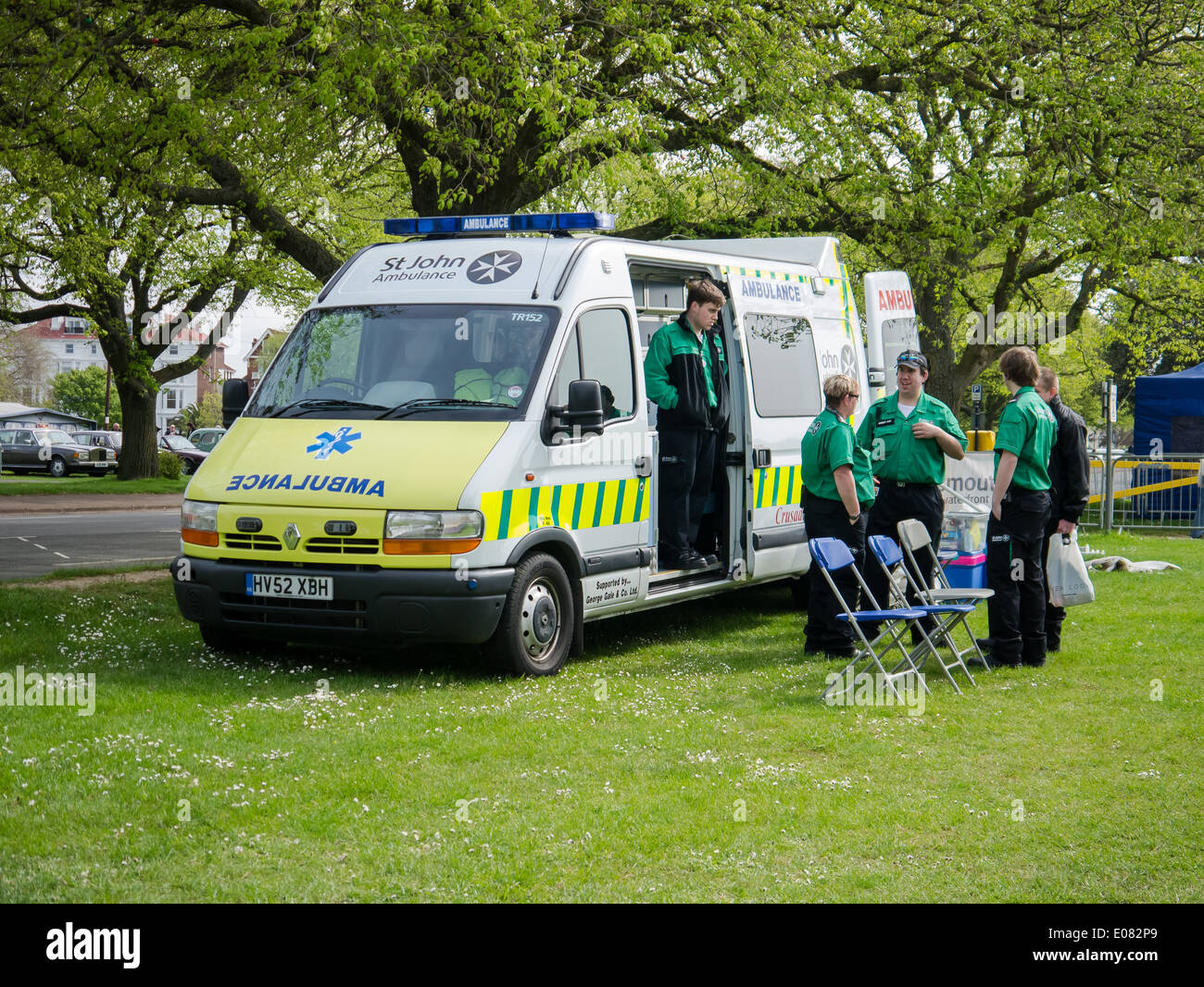 Members of St. John Ambulance providing emergency first aid cover from an ambulance at a community event. Stock Photo