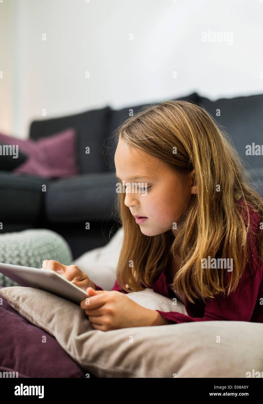 Girl using digital tablet in living room Stock Photo