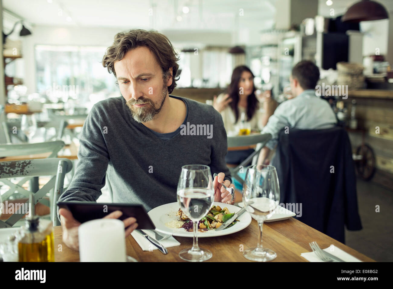 Mature man using digital tablet in restaurant Stock Photo