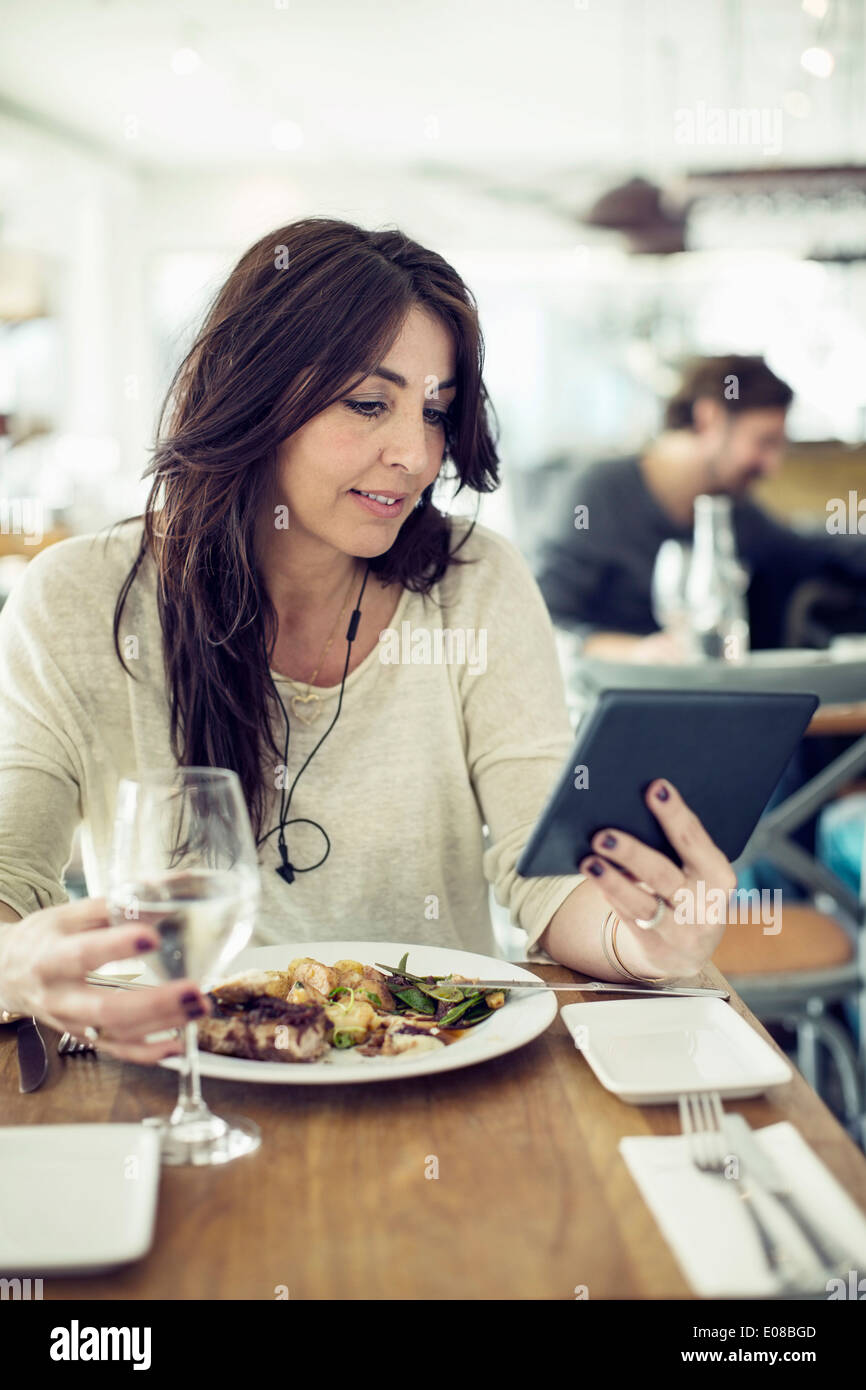 Woman using digital tablet in restaurant Stock Photo