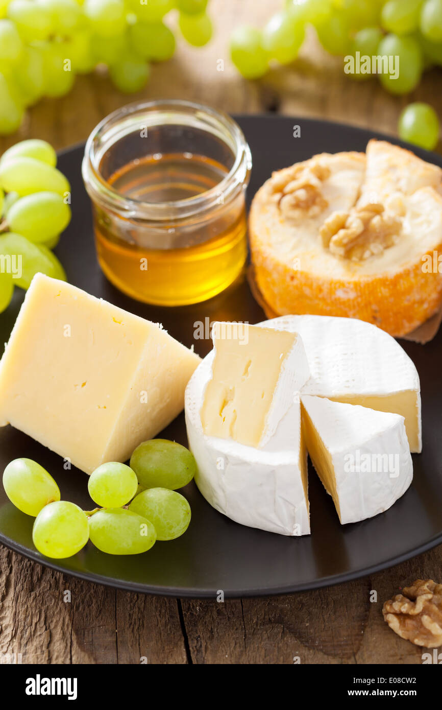 cheese plate with camembert, cheddar, grapes and honey Stock Photo