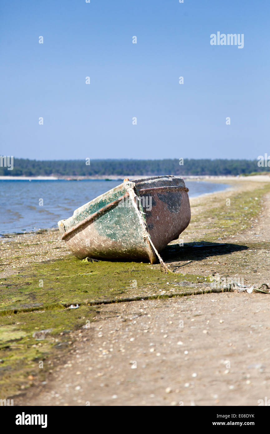Old and abandoned row boat on the beach. Lagoa de Albufeira beach, Sesimbra, Portugal. Stock Photo