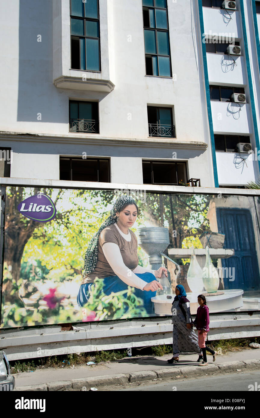 Tunis, Tunisia. Advert for sanitary towels showing a traditional woman cooking and a mother and daughter walking past Stock Photo