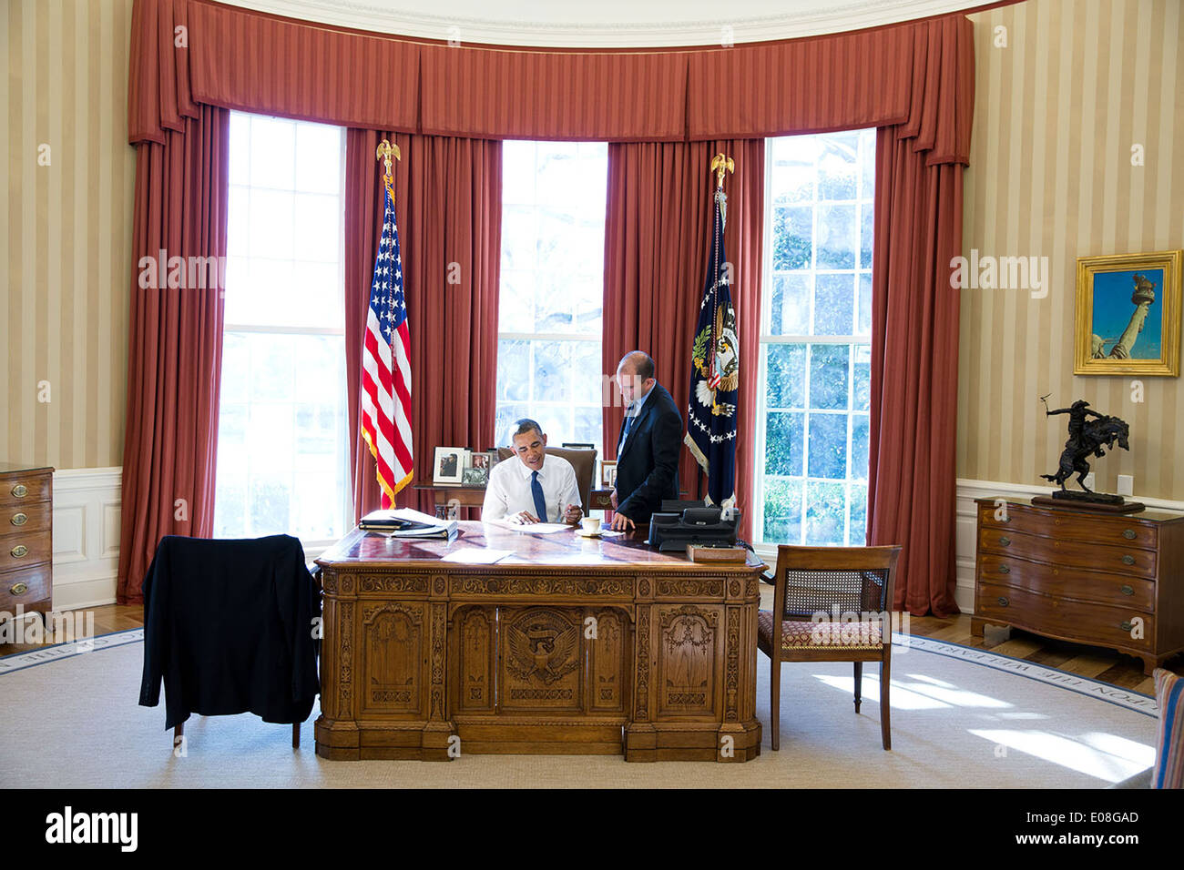 US President Barack Obama works in the Oval Office with Ben Rhodes, Deputy National Security Advisor for Strategic Communications, on remarks on the Administration's review of intelligence programs at the White House January 17, 2014 in Washington, DC. Stock Photo