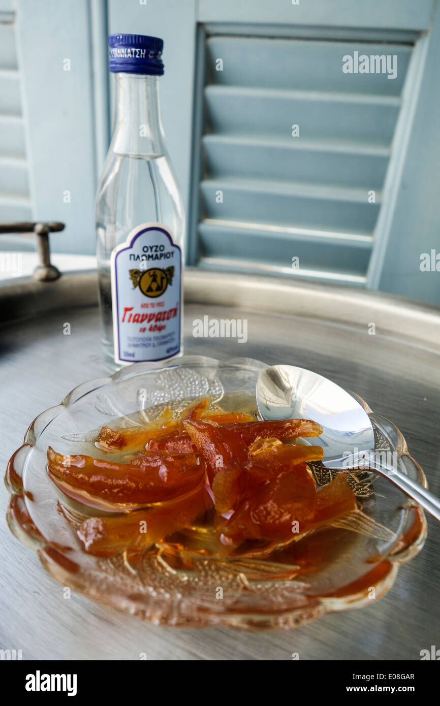 Greek Cuisine. Traditional Mandarin Orange Dessert and Bottle of locally made Ouzo, Mytilini, Greece Stock Photo